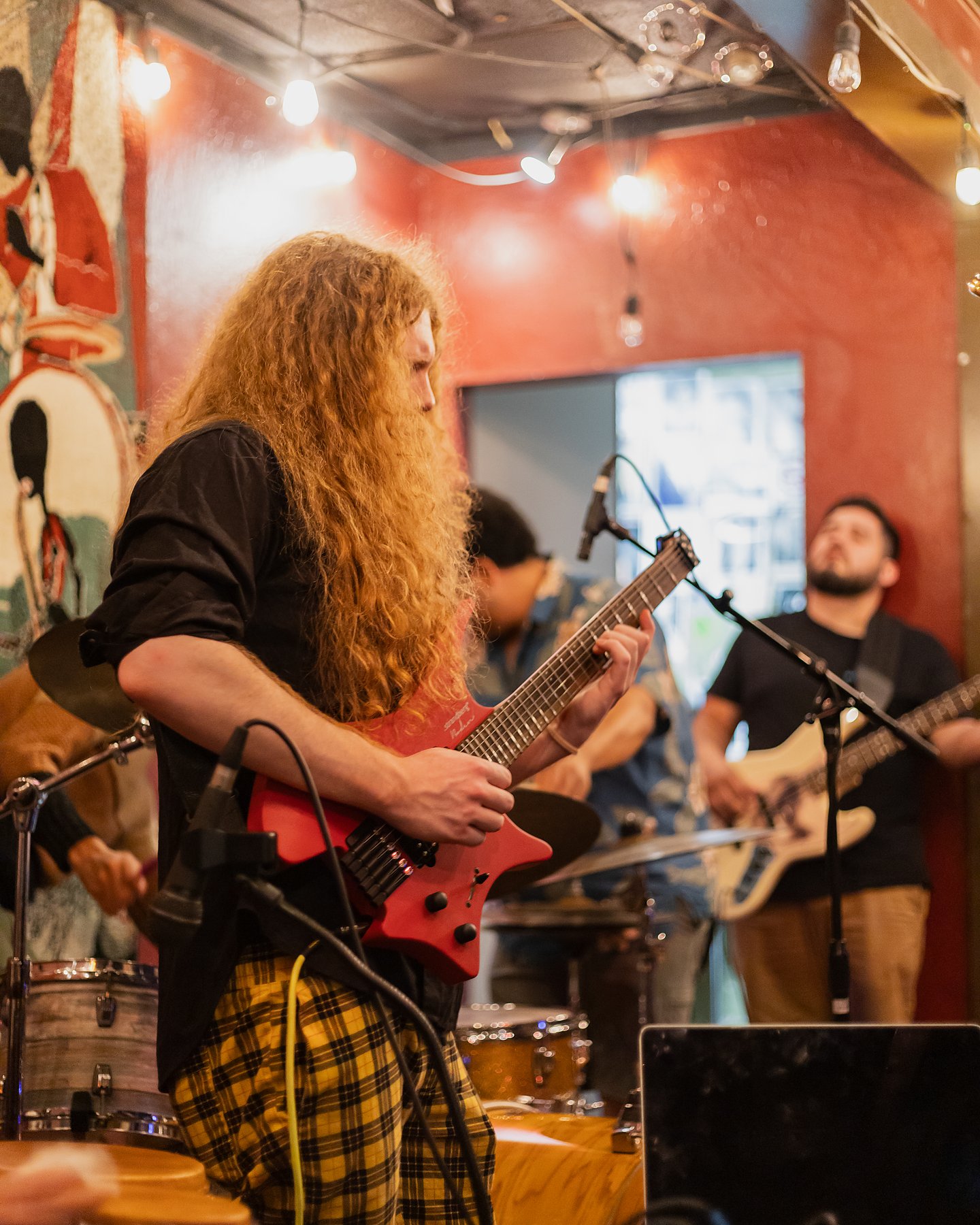 Sean Ashe performing electric guitar with a live band at the Torch Club.